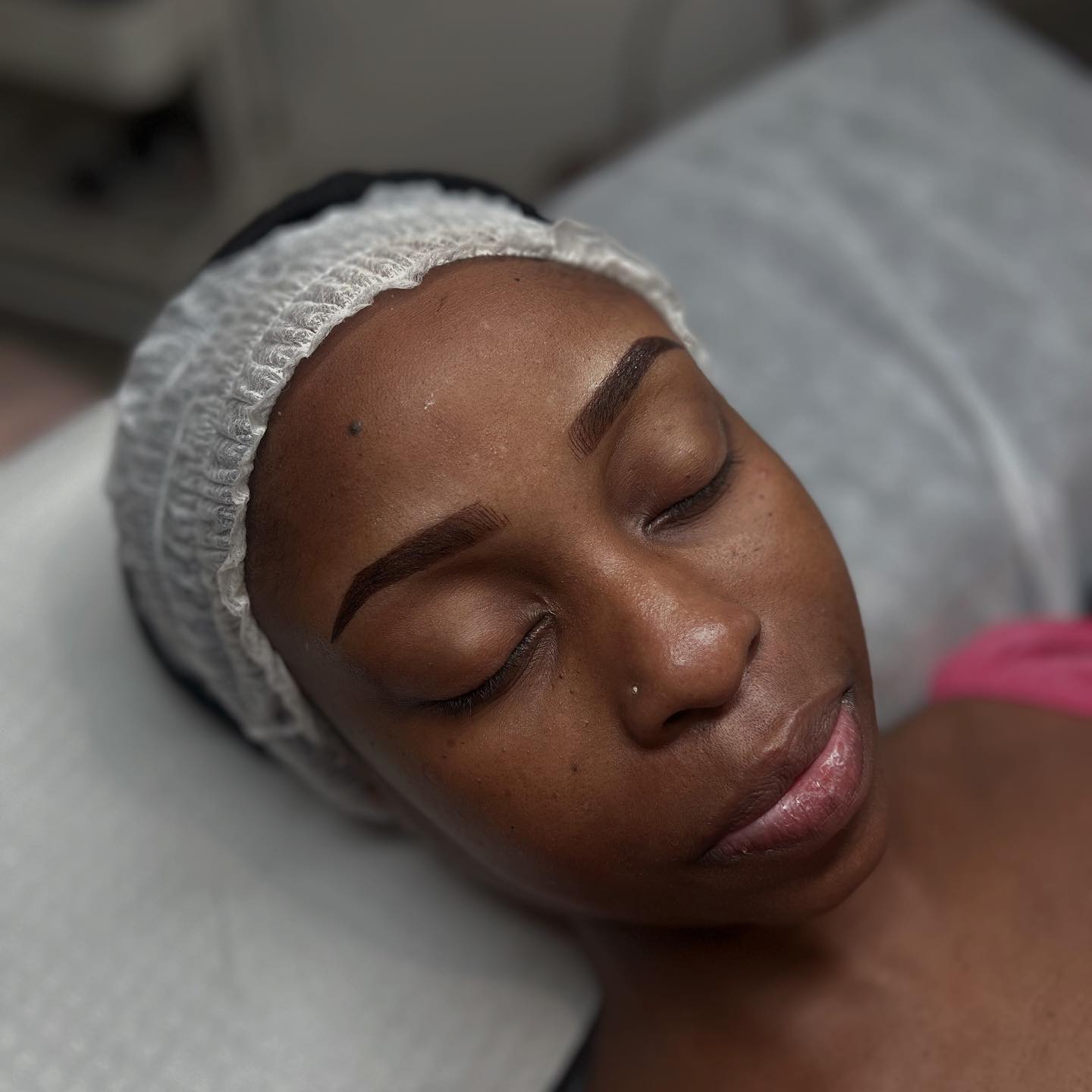 Precisely shaped brows on deep skin, mid treatment