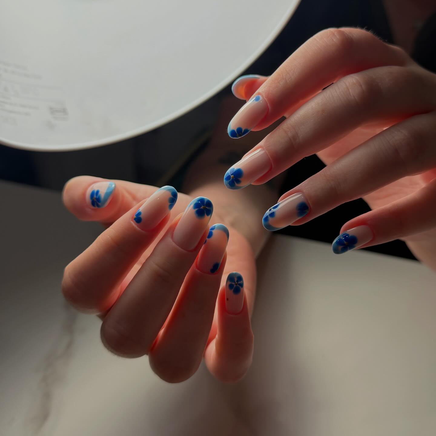 Milky nails with blue pansy floral tips