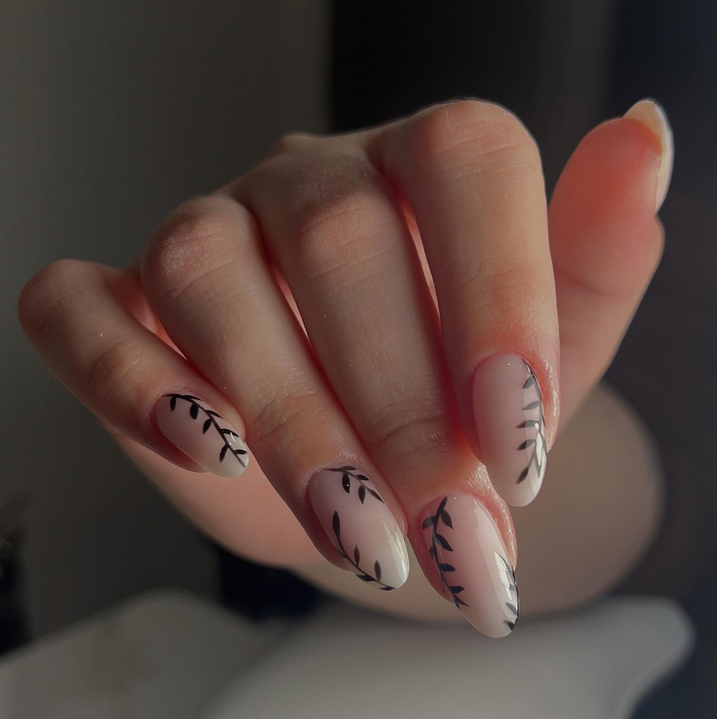 Nude almond nails with fine black botanical leaf art