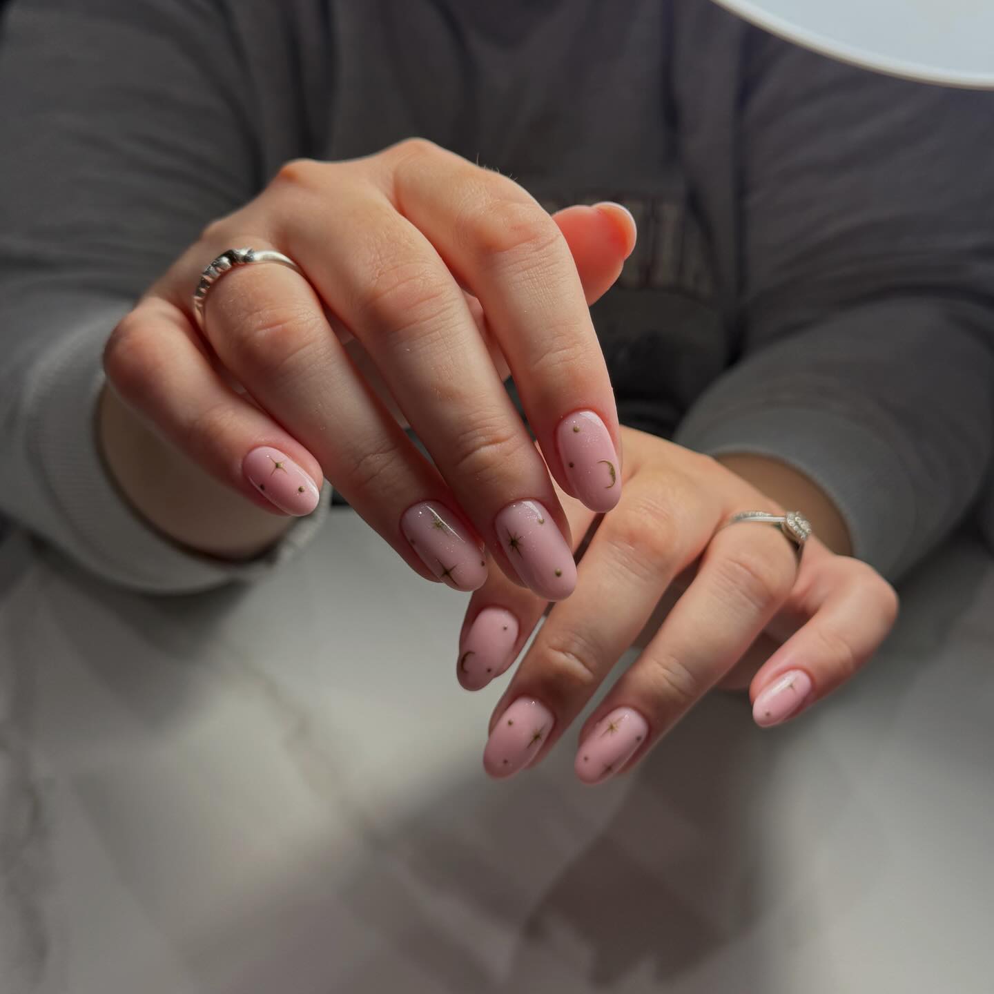 Soft pink nails with delicate stars and moons
